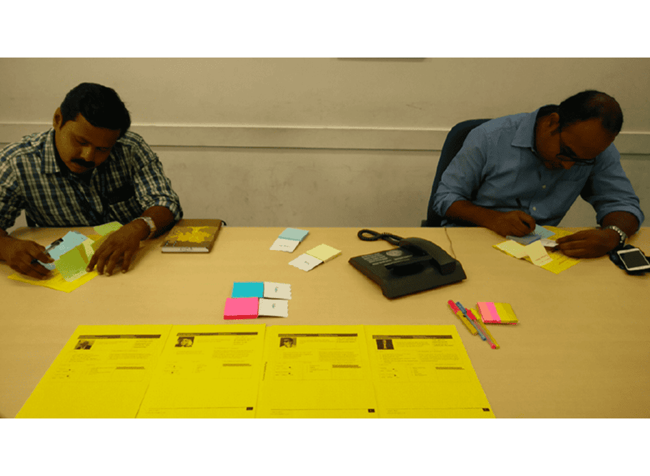 co-creation workshop: two participants working through printed persona and worksheet templates at a table